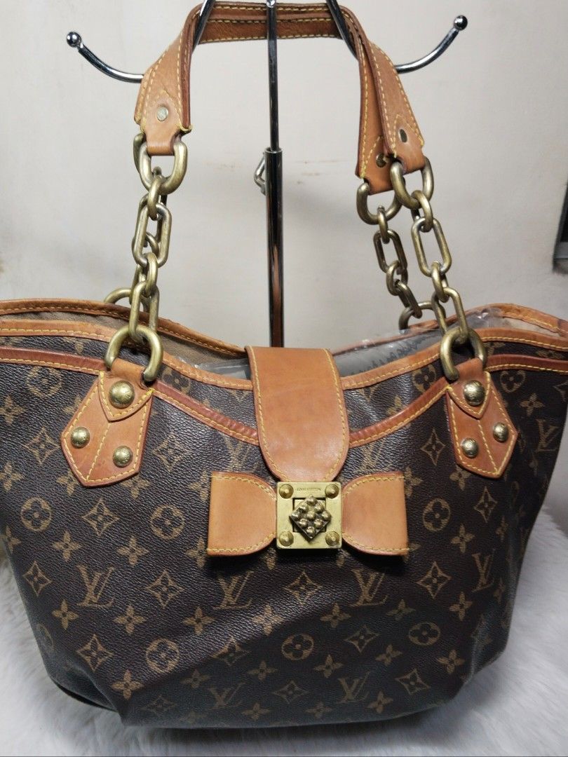 Louis Vuitton Monogram Canvas Tote Bag with Bow and Chain Strap (Category: Luxury Bags & Wallets) located in Manila. Submitted by mudrascloset.ph (Listing ID 1470647398, Image 1). Description: - Classic Monogram canvas tote bag with elegant brown leather trim - Secure front flap closure featuring a cute leather bow and metallic lock accent - Comfortable double chain and leather shoulder straps - Spacious lined interior with four protective feet o