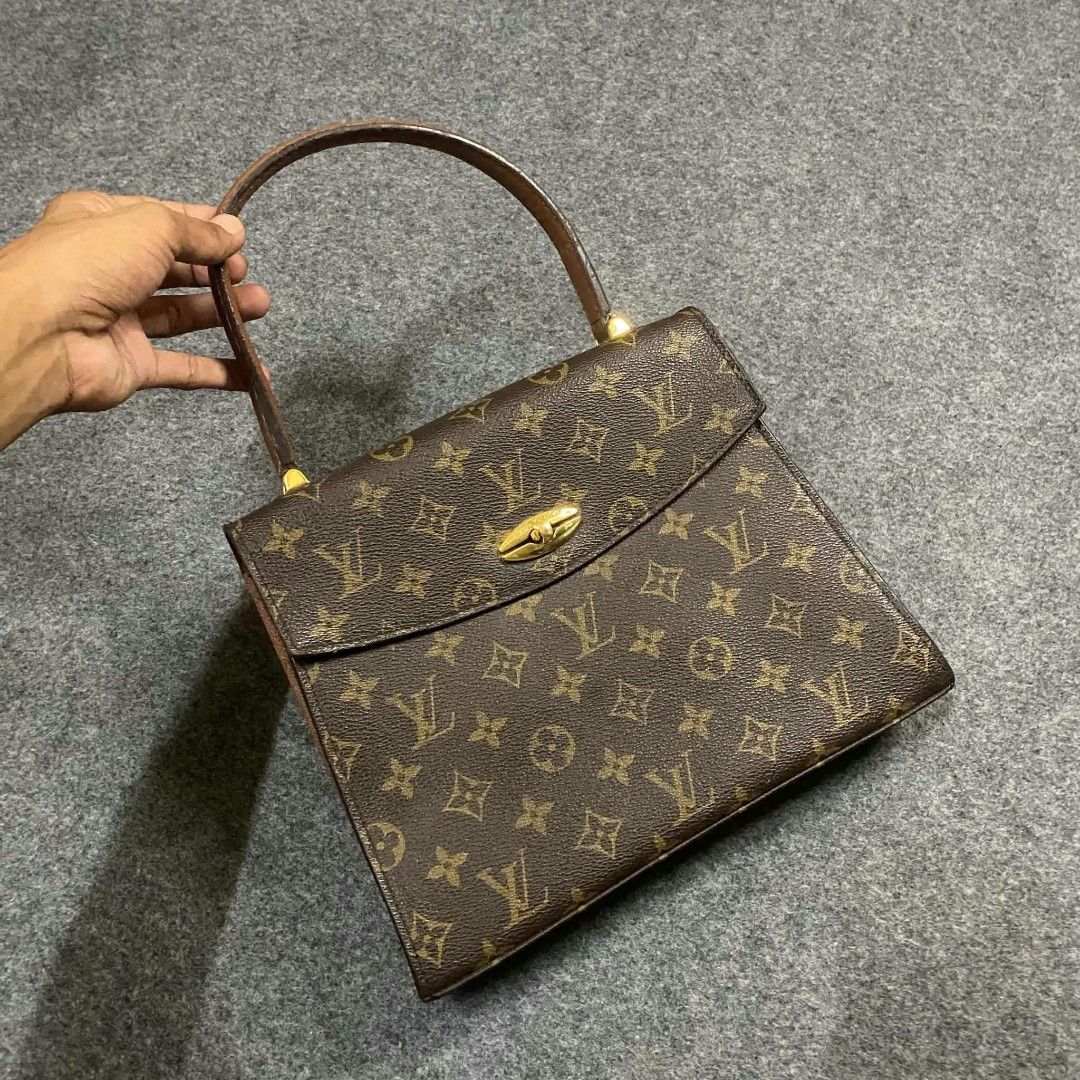 Louis Vuitton Monogram Canvas Handbag (Category: Luxury Bags & Wallets) located in Lapu Lapu. Submitted by margaux099 (Listing ID 1470692436, Image 2). Description: -Orig/authentic - Classic Louis Vuitton monogram canvas with brown leather top handle - Structured trapezoid shape with clean brown interior lining - Secure gold-tone hardware closure with engraved front flap lettering - Condition: Handle shows light rubbing/wear from past use, and me