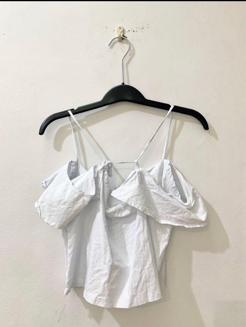 Love Ara White Off-Shoulder Ruffle Strap Crop Top (Category: Sleeveless) located in Quezon City. Submitted by decluttering_alot (Listing ID 1470633573, Image 2). Description: - Style: White cold-shoulder crop top with delicate ruffle layers - Details: Spaghetti straps with thin back connecting detail - Material: Lightweight fabric, ideal for warm weather or outdoor shoots - Condition: Worn once for a brief shoot, practically clean and like new RF