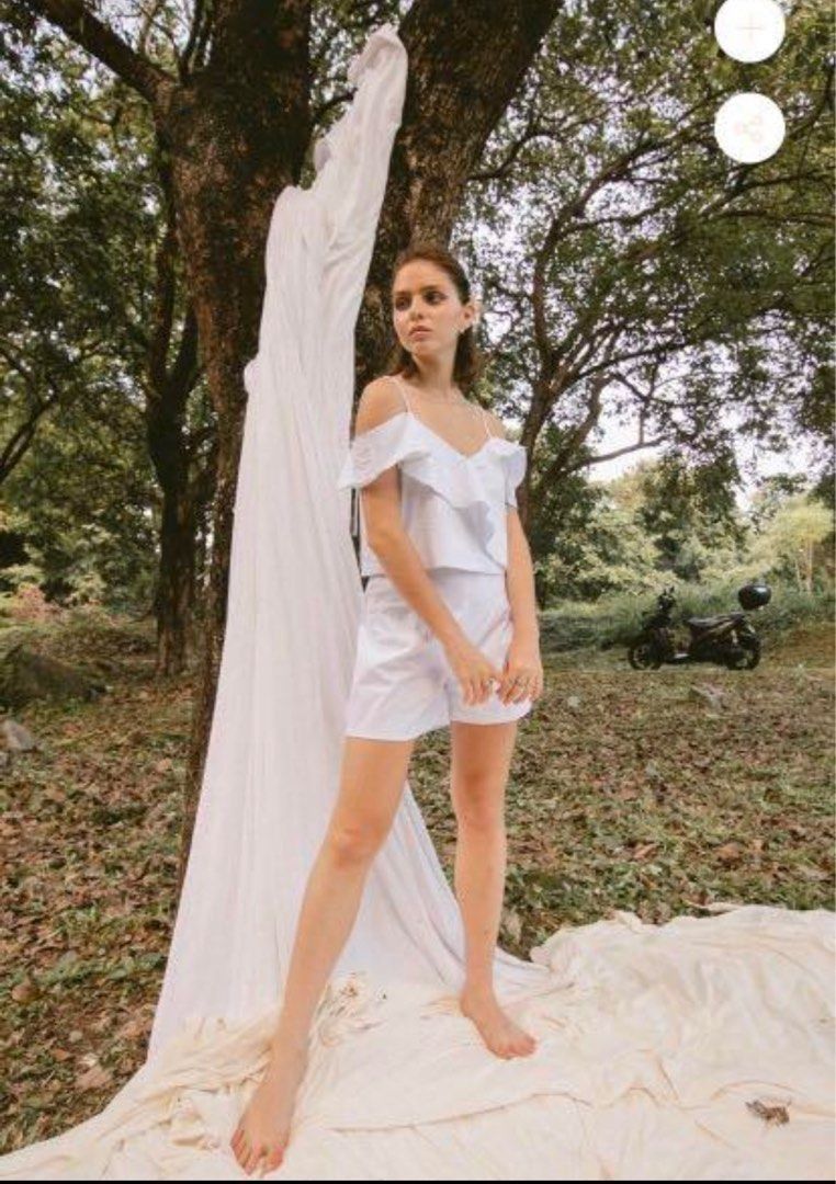 Love Ara White Off-Shoulder Ruffle Strap Crop Top (Category: Sleeveless) located in Quezon City. Submitted by decluttering_alot (Listing ID 1470633573, Image 1). Description: - Style: White cold-shoulder crop top with delicate ruffle layers - Details: Spaghetti straps with thin back connecting detail - Material: Lightweight fabric, ideal for warm weather or outdoor shoots - Condition: Worn once for a brief shoot, practically clean and like new RF