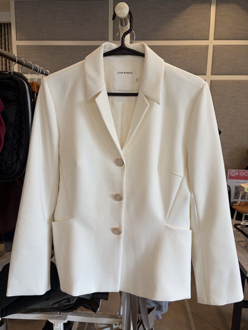 Love Bonito White Blazer Size L (Category: Coats, Jackets and Outerwear) located in Mandaluyong City. Submitted by francespringcleans (Listing ID 1470601986, Image 1). Description: - Brand: Love Bonito - Color: Solid White - Size: L (tag on collar) - Style: Structured cut with notched lapels and three front buttons - Features: Two functional front pockets - Condition: Clean, no stains spotted - Versatility: Ideal for corporate workwear or smart c