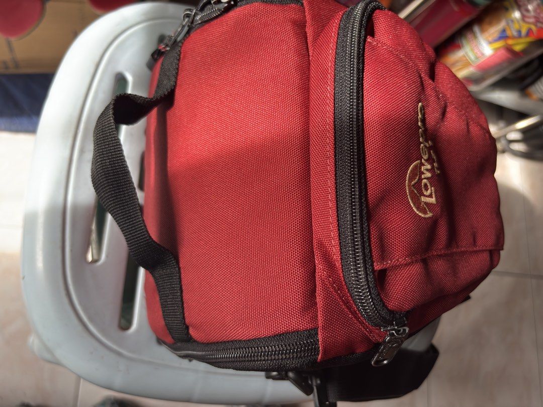 Lowepro TLZ 1 Camera Holster Bag Red Black (Category: Camera Bags & Carriers) located in Santa Rosa. Submitted by heckler03 (Listing ID 1470593188, Image 3). Description: - Model: Lowepro TLZ 1 Camera Holster Bag - Color: Stylish Red and Black - Material: Durable fabric construction - Storage: Front zippered pocket for small accessories - Portability: Includes top handle and adjustable shoulder strap - Compatibility: Quick-access design ideal for