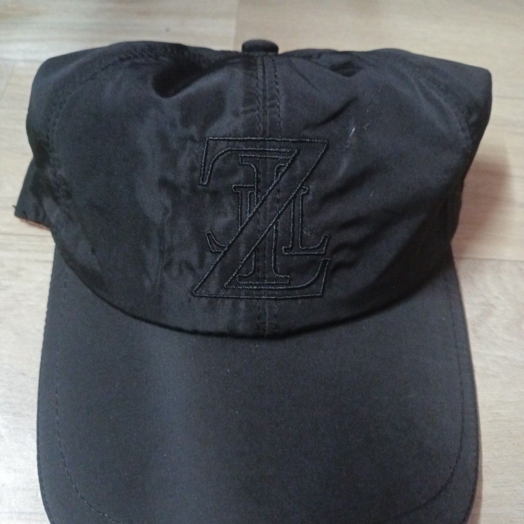 Maison Zilli Black Cap (Category: Caps & Hats) located in Manila. Submitted by itsnik444 (Listing ID 1470636193, Image 2). Description: - Brand: Zilli (Made in Italy) - Color: Black with bright yellow interior lining and orange trim - Design: Front embroidered monogram logo, repeating logo pattern inside, and curved brim - Size: Includes internal size label - Condition: 100% authentic designer piece.