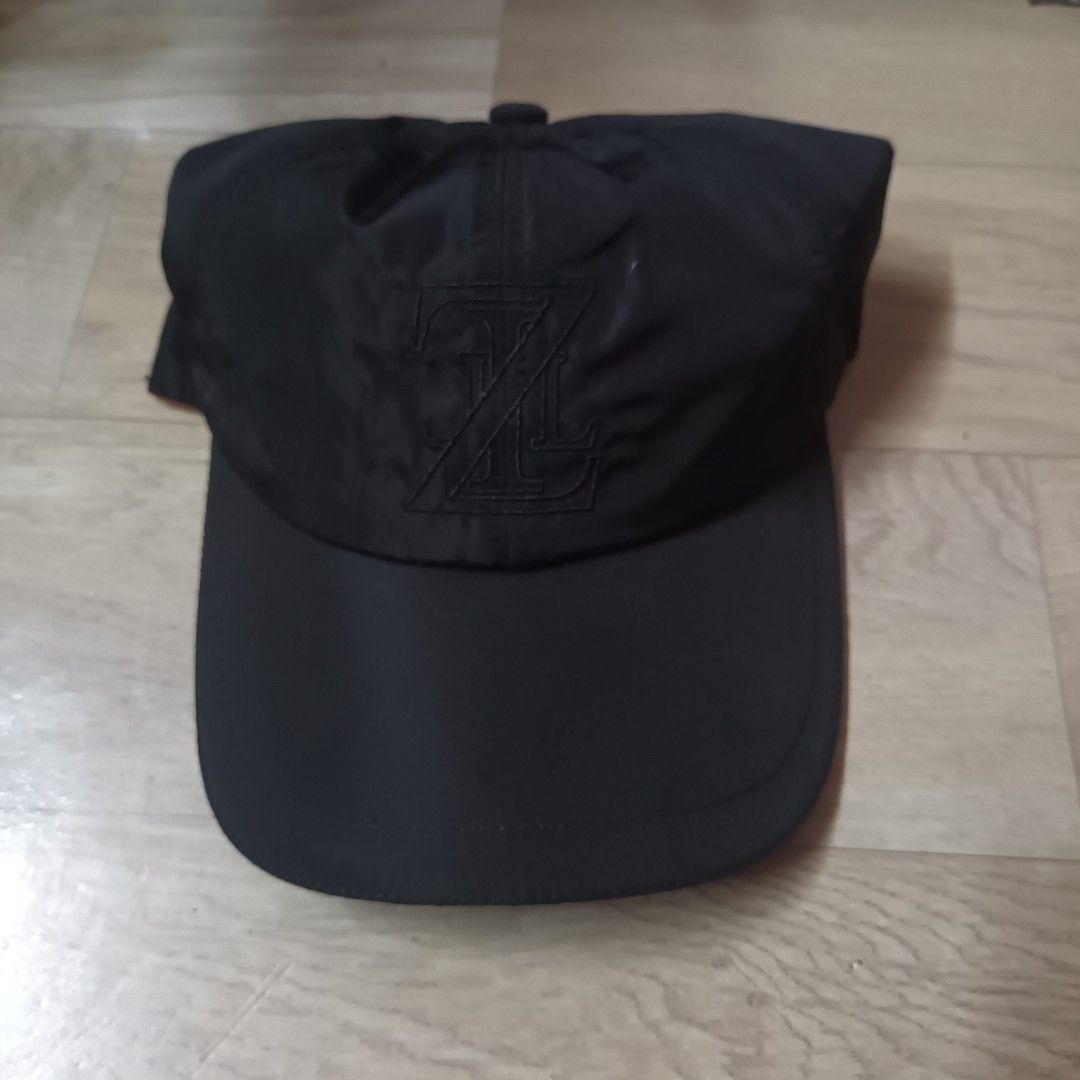 Maison Zilli Black Cap (Category: Caps & Hats) located in Manila. Submitted by itsnik444 (Listing ID 1470636193, Image 1). Description: - Brand: Zilli (Made in Italy) - Color: Black with bright yellow interior lining and orange trim - Design: Front embroidered monogram logo, repeating logo pattern inside, and curved brim - Size: Includes internal size label - Condition: 100% authentic designer piece.