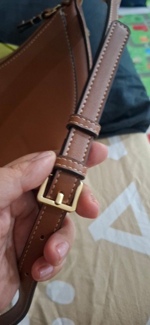 Mango brown half-moon shoulder bag (Category: Shoulder Bags) located in Paranaque City. Submitted by finders_thriftersph (Listing ID 1470674232, Image 2). Description: - Brand: Mango - Style: Half-moon shoulder bag - Color: Brown with gold-tone hardware - Closure: Secure zip closure - Strap: Adjustable with buckle - Interior: Cream fabric lining with brand tag - Size: Compact, ideal for daily essentials.