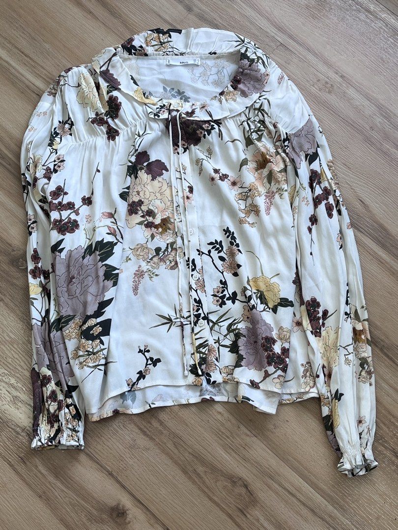 Mango Floral Top (Category: Blouses) located in Paranaque City. Submitted by PrelovedClosetetc (Listing ID 1470567357, Image 2). Description: Size M fits up to L Flowy fabric, Floral print, Baby doll neck, Long puffed sleeves, Bow fastening on the neck. 100% viscose.