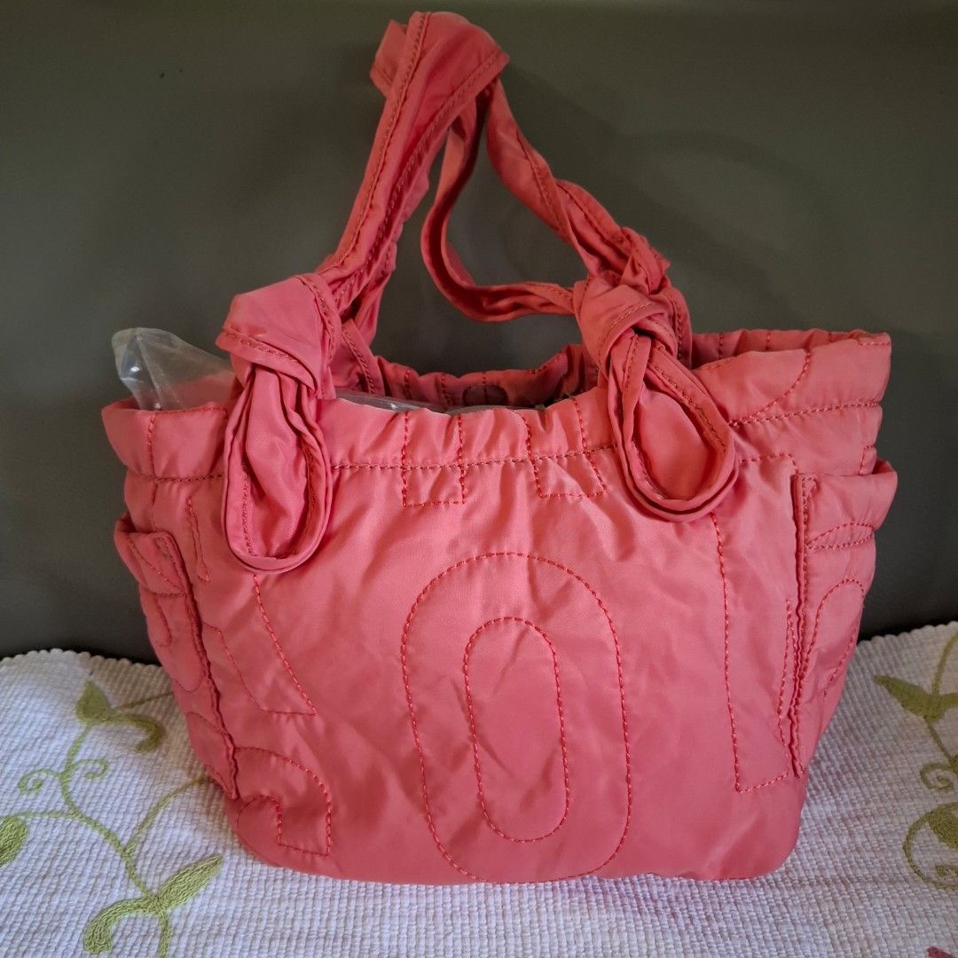 Marc by Marc Jacobs Pink Quilted Tote Bag (Category: Luxury Bags & Wallets) located in Don Carlos. Submitted by PphiXi_Finds (Listing ID 1470727108, Image 2). Description: - Brand: Marc by Marc Jacobs - Material: Bright pink quilted nylon with black and white monogram lining - Design: Bold exterior logo stitching with signature front plaque - Handles: Double knotted shoulder handles for a chic look - Storage: Convenient interior zip pocket and sl