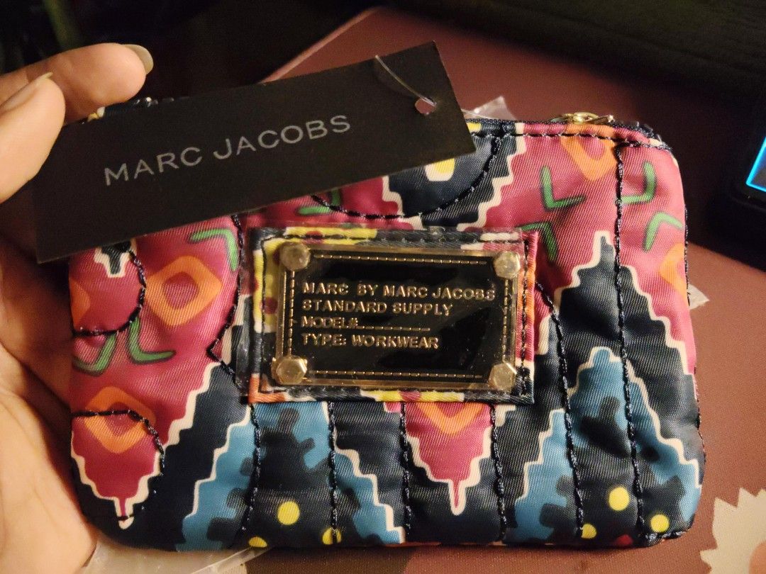 Marc by Marc Jacobs purse (Category: Luxury Bags & Wallets) located in Quirino. Submitted by megay12 (Listing ID 1470693044, Image 2). Description: - Brand: Marc by Marc Jacobs - Condition: Brand new, never removed from original plastic packaging - Design: Vibrant geometric pattern in pink, blue, orange, and black with gold-tone hardware - Interior: Classic black and white brand logo fabric lining - Extras: Includes attached black hang tag - Perf