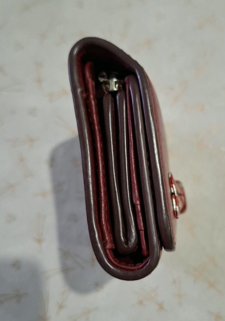 Marc Jacobs Red Leather Bow Wallet (Category: Luxury Bags & Wallets) located in Don Carlos. Submitted by PphiXi_Finds (Listing ID 1470726745, Image 3). Description: - Brand: Marc Jacobs New York - Material: Genuine red leather - Design: Compact trifold with snap closure - Features: Card slots, cash compartment, and zipped coin pocket - Accents: Unique striped silver and red bow hardware on the front flap - Condition: Minor wear along the edges an