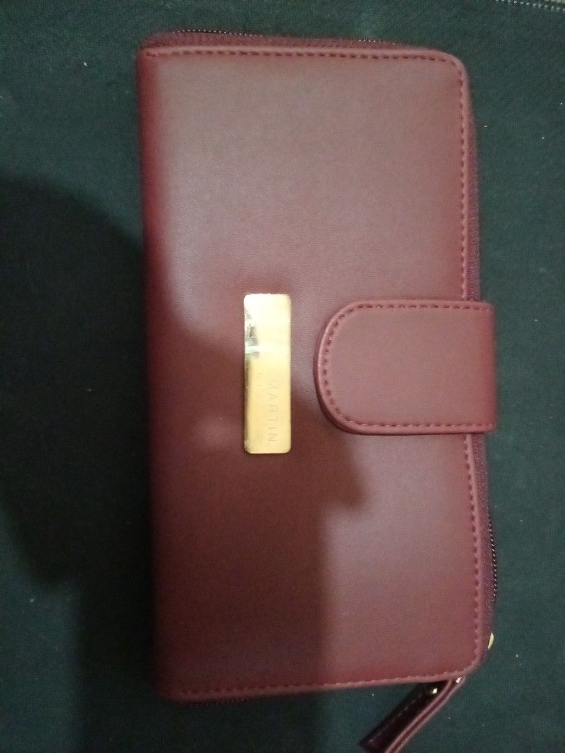 Martin Paris Maroon Long Zip Wallet (Category: Wallets & Card holders) located in Manila. Submitted by luckyeagle-7ff8 (Listing ID 1470590200, Image 1). Description: - Color: Maroon with elegant gold-tone hardware - Closures: Secure front flap with snap button and zippered coin pocket - Storage: Multiple card slots and spacious bill compartments - Interior: Clean lining featuring a stylish striped pattern in cash pockets - Size: Perfect dimension