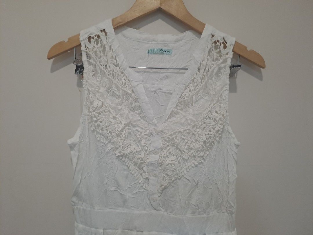Maurices white dress (Category: Dresses) located in Manila. Submitted by joanbalde39643 (Listing ID 1470661358, Image 2). Description: This is a sleeveless white casual dress featuring a distinctive V-neckline framed by ornate crochet-style lace paneling. It is designed with a defined waistband and a lightweight, crinkled fabric texture throughout the skirt section, giving it an effortless, bohemian-inspired look perfect for summer or resort wear