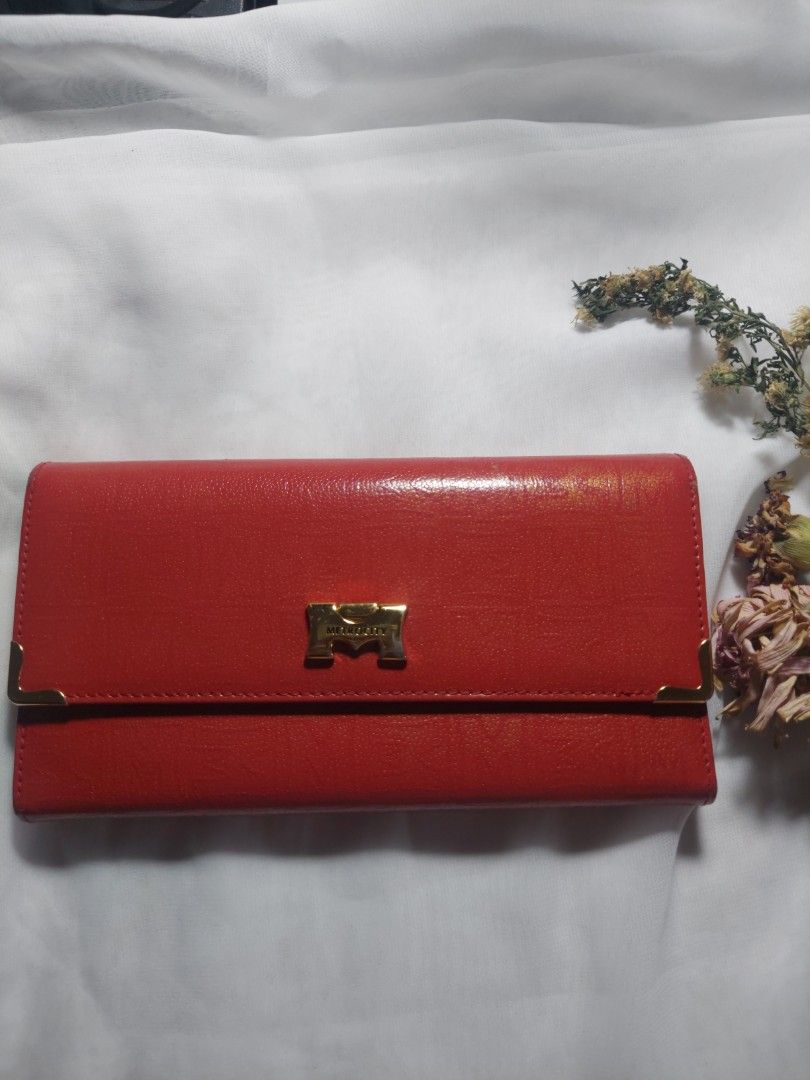 Metrocity Red Leather Long Wallet (Category: Wallets & Card holders) located in Quezon City. Submitted by never_a_clutter (Listing ID 1470591419, Image 1). Description: - Brand: Metrocity - Color: Bright red with gold hardware details - Material: Genuine leather - Closure: Secure snap button - Interior: Multiple card slots, ID window, long slip compartments, and zippered coin pocket - Lining: Signature Metrocity monogram pattern - Condition: 9/10
