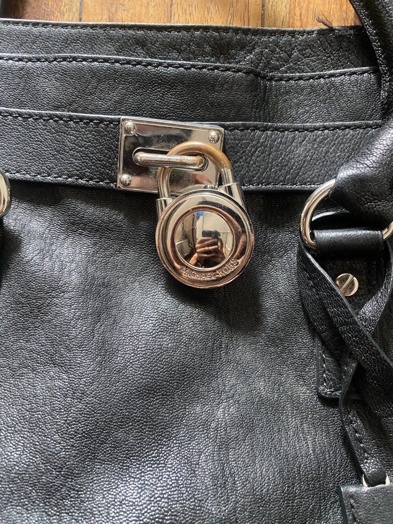 Michael Kors Black Leather Handbag with Padlock (Category: Luxury Bags & Wallets) located in Manila. Submitted by anthony1723 (Listing ID 1470697437, Image 2). Description: - Brand: Michael Kors - Material: Genuine black leather with silver-tone hardware - Design: Signature padlock detail, dual top handles, and included shoulder strap - Interior: MK logo fabric lining with secure zipped compartments and multi-purpose pockets - Condition: Exterior