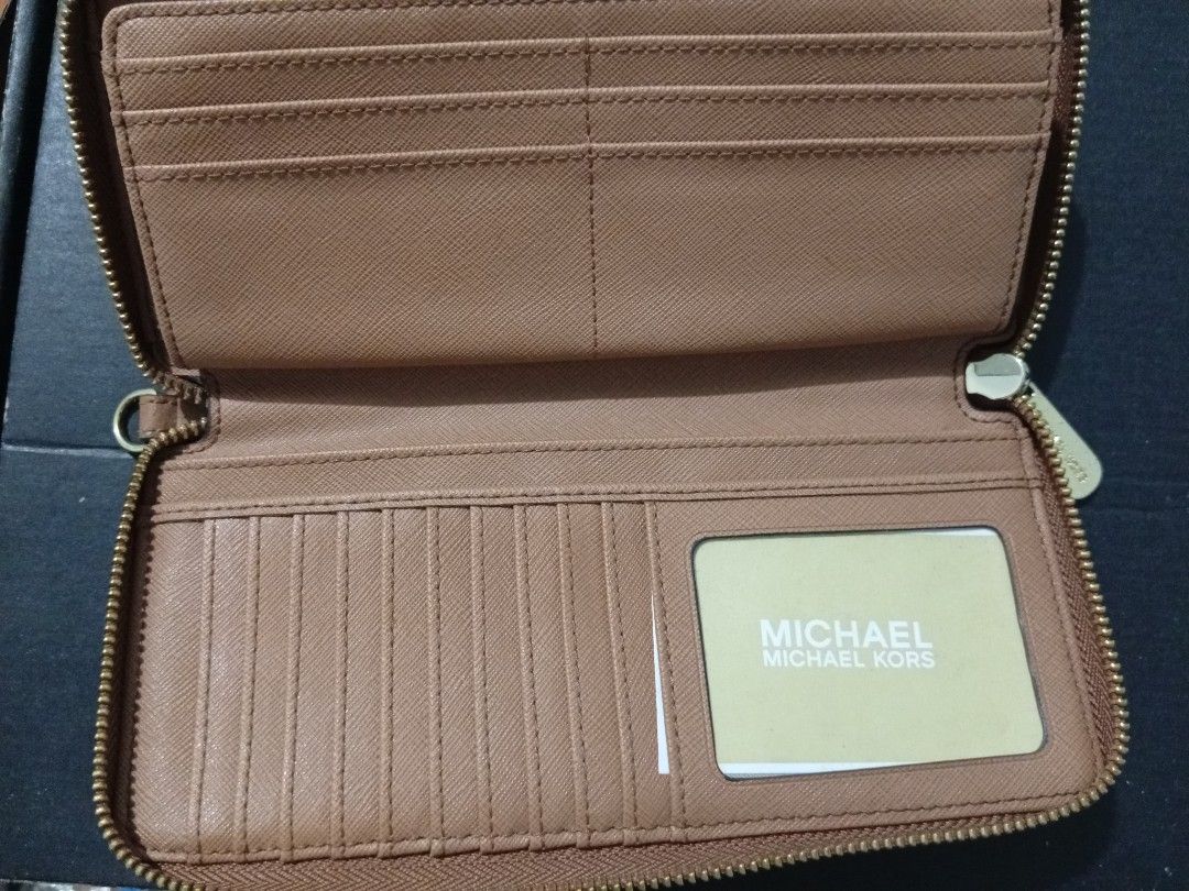 Michael Kors Jet Set (Category: Wallets & Card holders) located in Aroroy. Submitted by gabrielle.otc (Listing ID 1470665235, Image 2). Description: Michael Kors zip-around wallet in signature beige and tan canvas. Gold-tone hardware with engraved logo plaque on the front. Tan interior lining featuring multiple card slots, compartments, and an ID window slot. Clean inside and out, plenty of space for cards and cash..