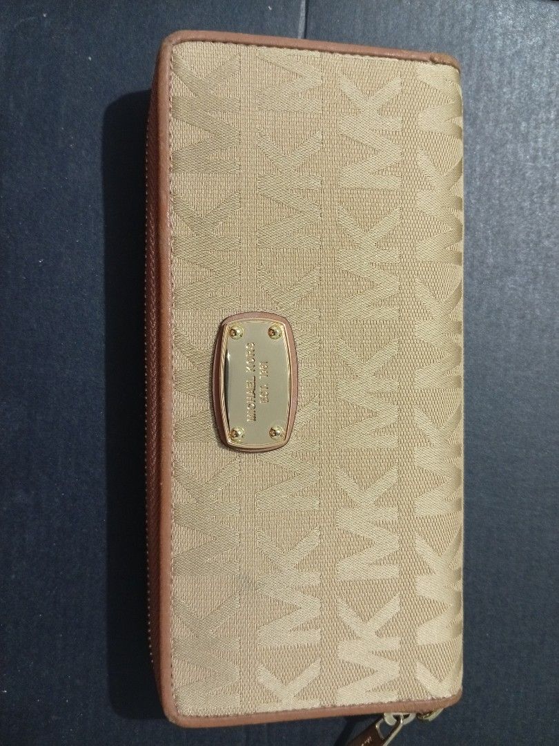 Michael Kors Jet Set (Category: Wallets & Card holders) located in Aroroy. Submitted by gabrielle.otc (Listing ID 1470665235, Image 1). Description: Michael Kors zip-around wallet in signature beige and tan canvas. Gold-tone hardware with engraved logo plaque on the front. Tan interior lining featuring multiple card slots, compartments, and an ID window slot. Clean inside and out, plenty of space for cards and cash..