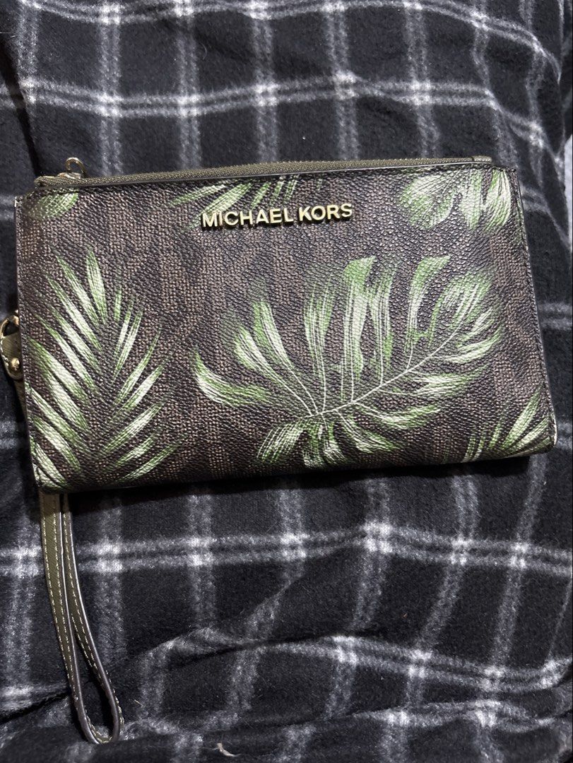 Michael Kors Leaf Print Wristlet Wallet (Category: Wallets & Card holders) located in Las Pinas. Submitted by pamboi (Listing ID 1470570210, Image 1). Description: - Brand: Michael Kors - Design: Brown and green leaf print with gold-tone hardware - Interior: Olive green leather with multiple card slots and ID window - Closure: Secure snap closure and dual zippered compartments - Extras: Includes removable wrist strap - Condition: Clean inside and