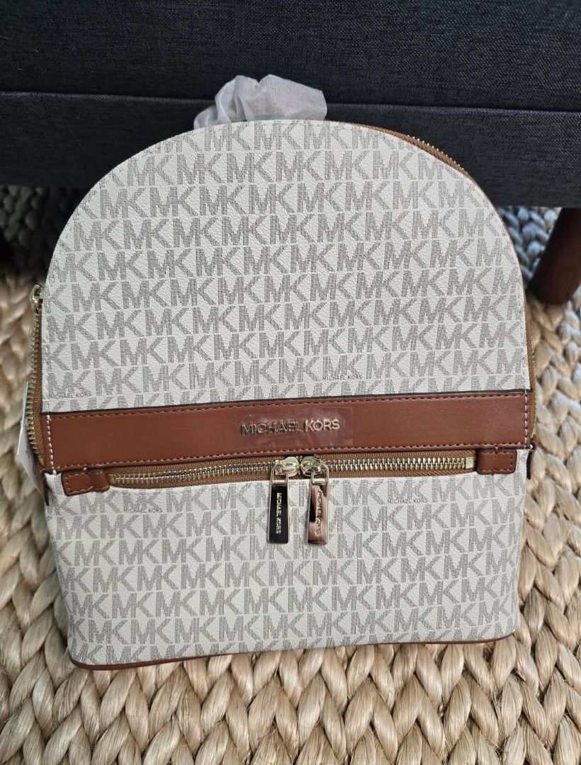 Michael Kors Signature Vanilla Brown Backpack (Category: Backpacks) located in Pasig City. Submitted by pretty.little_things (Listing ID 1470697966, Image 1). Description: - Authentic Michael Kors dome backpack - Classic vanilla and brown monogram print with brown leather trim - Elegant gold-tone hardware - Convenient front zip pocket and dual adjustable shoulder straps - Brand new and never used, pristine condition - Original protective paper st