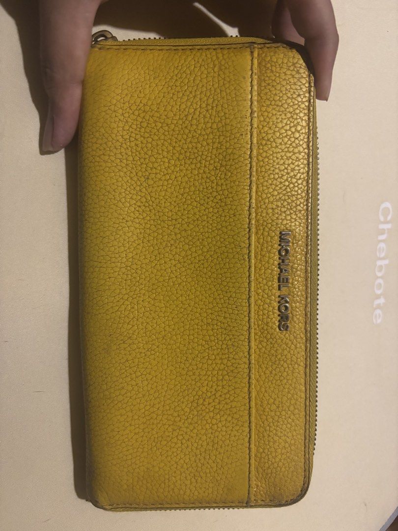 Authentic Michael Kors Yellow Leather Zip Around Wallet (Category: Wallets & Card holders) located in Manila. Submitted by jodiein67146 (Listing ID 1470715355, Image 1). Description: - Brand: Michael Kors bought from Japan - Material: Bright yellow leather - Closure: Zip-around for secure storage - Interior: Multiple card slots, slip pockets, and a zippered coin compartment - Exterior: Front pocket for quick access - Lining: Signature Michael Kor