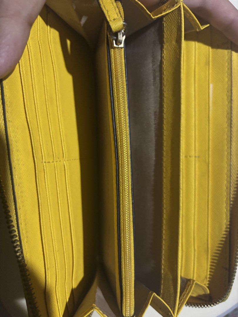Authentic Michael Kors Yellow Leather Zip Around Wallet (Category: Wallets & Card holders) located in Manila. Submitted by jodiein67146 (Listing ID 1470715355, Image 3). Description: - Brand: Michael Kors bought from Japan - Material: Bright yellow leather - Closure: Zip-around for secure storage - Interior: Multiple card slots, slip pockets, and a zippered coin compartment - Exterior: Front pocket for quick access - Lining: Signature Michael Kor