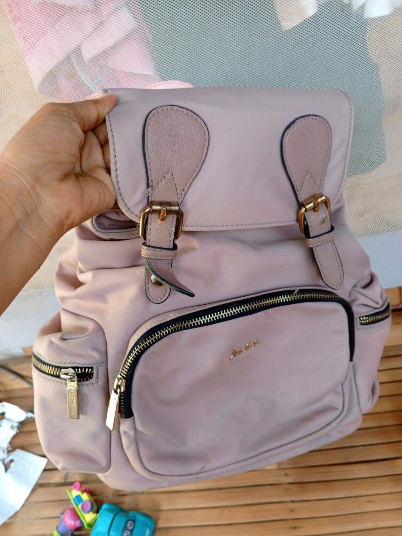 MICHAELA Dusty Pink Backpack with Front Pocket (Category: Backpacks) located in Binmaley. Submitted by ezekislacl02490 (Listing ID 1470591951, Image 1). Description: - Brand: MICHAELA - Color: Dusty pink with black adjustable straps and gold-toned hardware - Material: Nylon body with faux leather flap and trim - Compartments: Multiple zippered pockets on the front and sides - Condition: Fair; minor faux leather peeling on the top handle and botto
