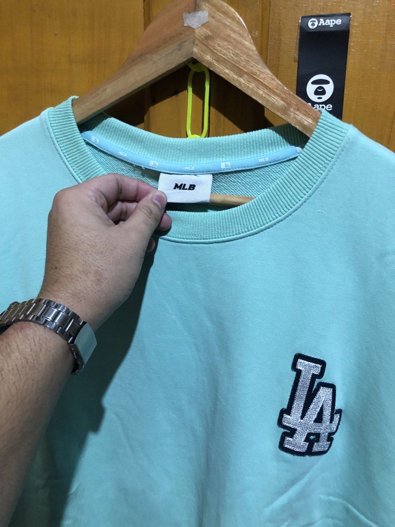 MLB Los Angeles Dodgers Mint Green Sweatshirt (Category: Coats, Jackets and Outerwear) located in Manila. Submitted by streetwear_only (Listing ID 1470727640, Image 3). Description: - Authentic MLB Los Angeles Dodgers sweatshirt - Color: Mint green - Size: Small - Small embroidered LA logo on the chest - Large LA logo patch graphic printed on the back - Classic crew neck style with ribbed cuffs and hem - Inner collar tape branding - Original bran