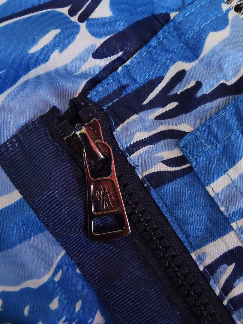 Moncler Blue Camo Hooded Windbreaker Jacket (Category: Coats, Jackets and Outerwear) located in General Santos City (Dadiangas). Submitted by candaceazu76865 (Listing ID 1470686917, Image 2). Description: - Brand: Moncler - Style: Hooded windbreaker in blue camouflage - Details: Full zip front, branded hardware, drawstring hood, sleeve utility pocket - Authenticity: Interior brand patch and authentication label included - Condition: Clean, solid 