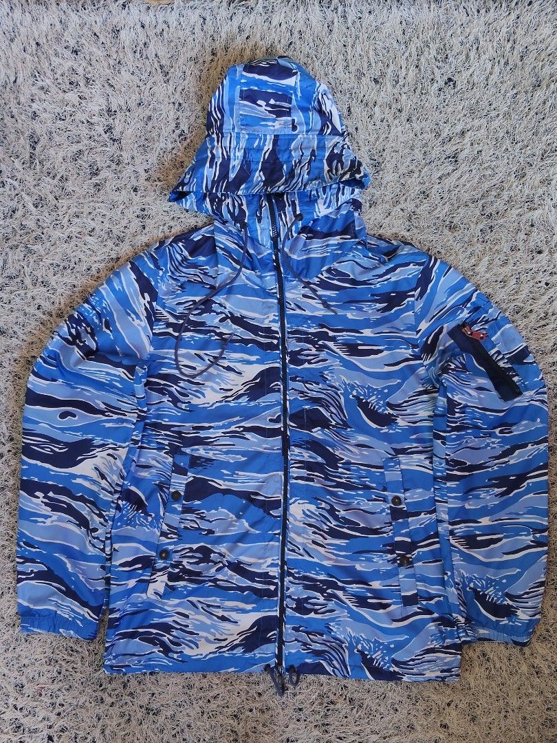 Moncler Blue Camo Hooded Windbreaker Jacket (Category: Coats, Jackets and Outerwear) located in General Santos City (Dadiangas). Submitted by candaceazu76865 (Listing ID 1470686917, Image 1). Description: - Brand: Moncler - Style: Hooded windbreaker in blue camouflage - Details: Full zip front, branded hardware, drawstring hood, sleeve utility pocket - Authenticity: Interior brand patch and authentication label included - Condition: Clean, solid 