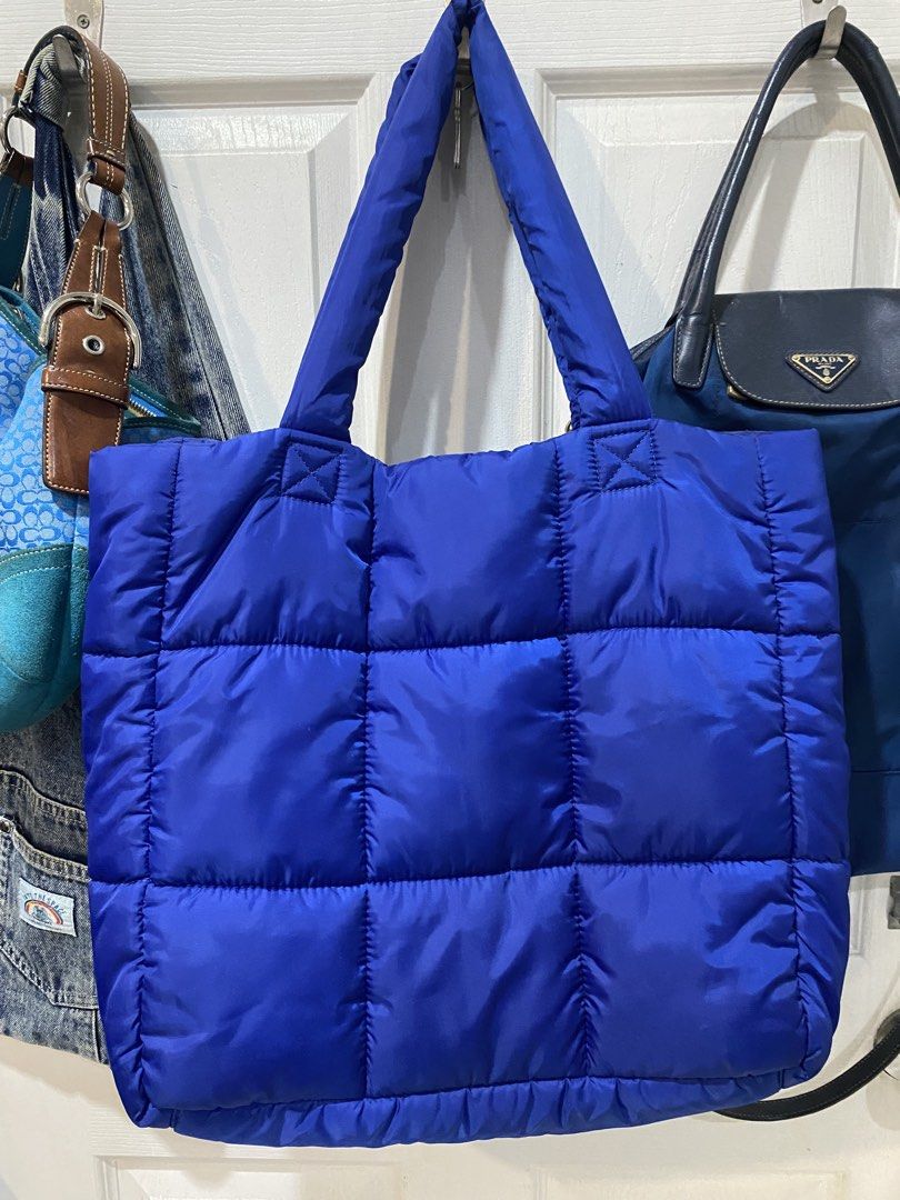 Monkl Puffer Tote Bag Blue Quilted (Category: Tote Bags) located in Manila. Submitted by rei.willdeclutter (Listing ID 1470698668, Image 2). Description: - Brand: Monki - Style: Quilted tote bag - Color: Royal blue - Material: Puffy nylon with grid stitching - Straps: Dual top shoulder straps - Closure: Magnetic snap button - Storage: Includes one interior zipper pocket - Condition: Clean inside and out, ready to use.