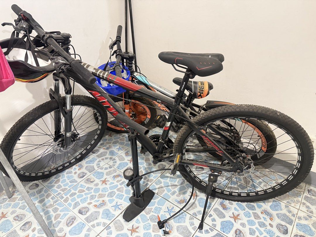 Mountain Bike and Floor Pump Set (Category: Bicycles) located in Manila. Submitted by hazeleran030614 (Listing ID 1470639578, Image 3). Description: - Bundle includes: 2 mountain bikes and 1 black floor pump - Bike 1: Black and red with suspension forks and disc brakes - Bike 2: Black and orange with suspension forks and disc brakes - Floor pump: Includes a convenient pressure gauge at the base - Ideal for: Weekend trail rides and daily commuting