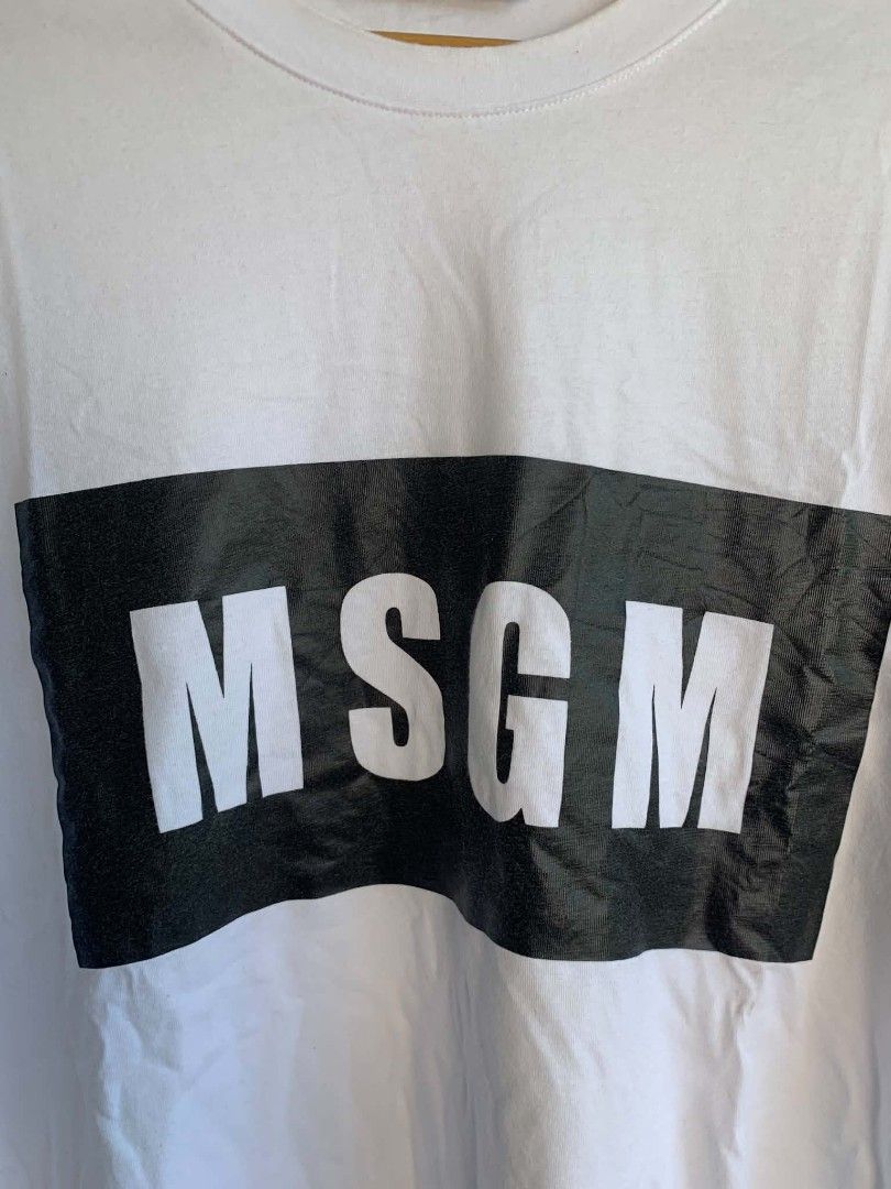 MSGM Milano White T-shirt with Black Logo Box (Category: Shirts) located in Manila. Submitted by michaelge38472 (Listing ID 1470705192, Image 2). Description: - Brand: MSGM Milano - Color: White - Style: Short sleeve tee with classic crew neck - Design: Large black box graphic with bold white lettering on the chest - Condition: Clean, minimal signs of wear - Vibe: Classic streetwear staple.