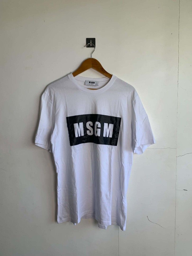MSGM Milano White T-shirt with Black Logo Box (Category: Shirts) located in Manila. Submitted by michaelge38472 (Listing ID 1470705192, Image 1). Description: - Brand: MSGM Milano - Color: White - Style: Short sleeve tee with classic crew neck - Design: Large black box graphic with bold white lettering on the chest - Condition: Clean, minimal signs of wear - Vibe: Classic streetwear staple.