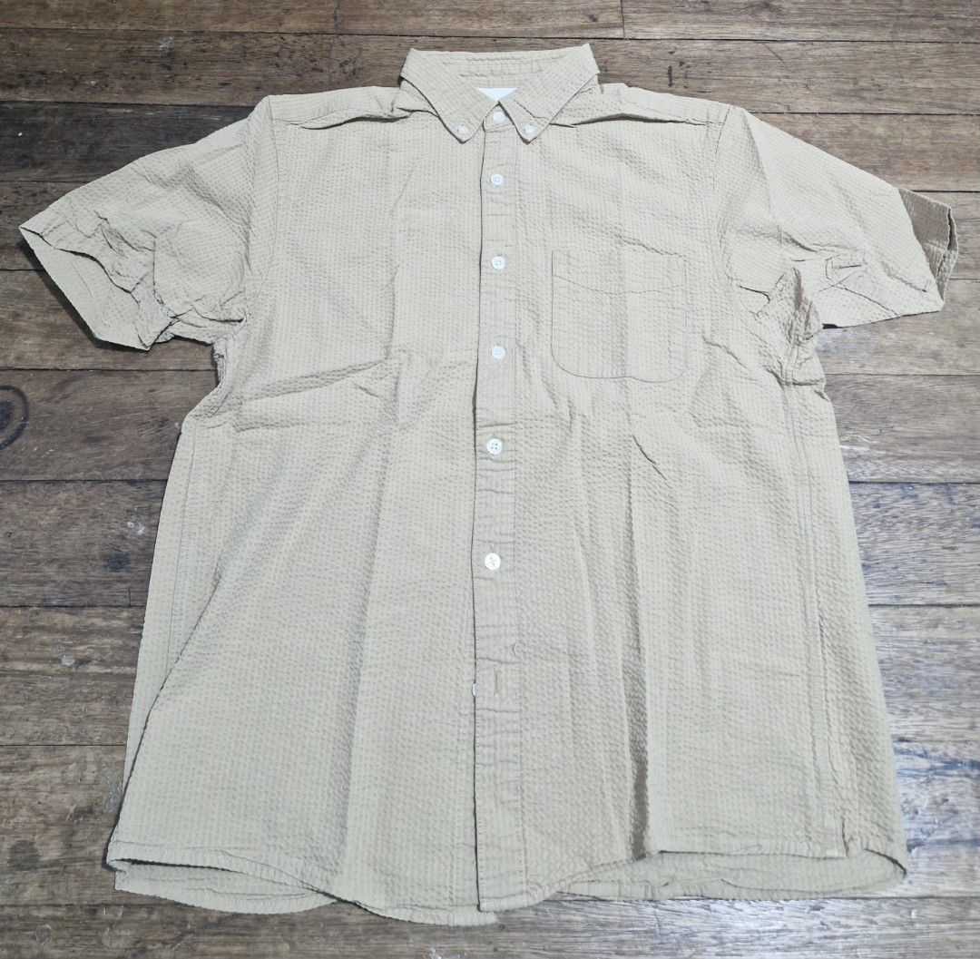 Muji beige Short Sleeve Button down (Category: Tshirts & Polo Shirts ) located in Manila. Submitted by martinezjonill (Listing ID 1470586265, Image 1). Description: - Color: Classic beige - Material: Lightweight, breathable seersucker textured fabric - Fit: Relaxed fit for all-day comfort in warm weather - Details: Standard collar, white front buttons, and single left chest pocket - Styling: Pairs effortlessly with denim jeans or smart chinos .