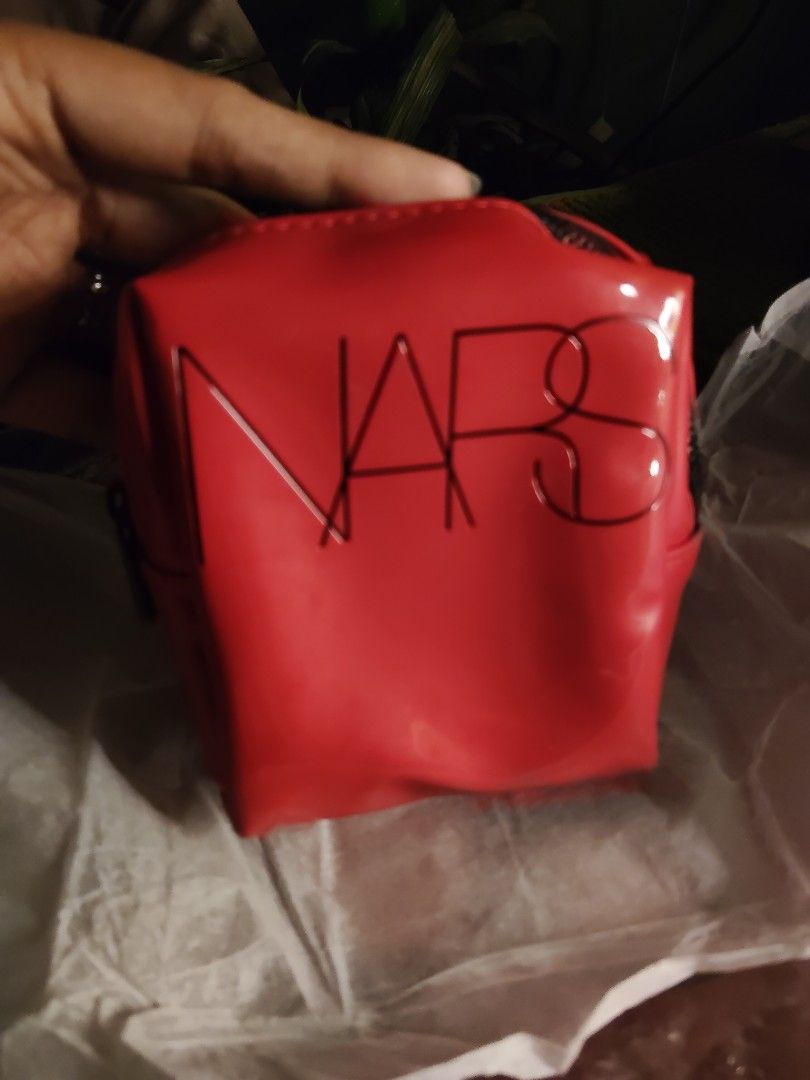 NARS Red Patent Makeup Bag Cosmetic Pouch (Category: Purses & Pouches) located in Quirino. Submitted by megay12 (Listing ID 1470696772, Image 3). Description: - Brand: NARS - Color: Bright red with shiny patent finish - Details: Embossed black logo lettering on the front, secure zip-top closure - Size: Compact boxy shape, ideal for travel or daily essentials - Condition: Pristine, clean inside and out.