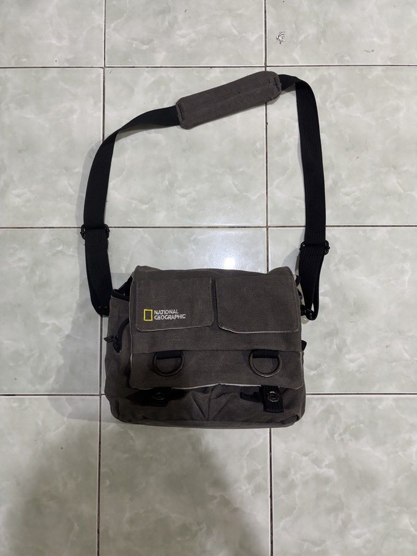National Geographic Canvas Camera Messenger Bag (Category: Camera Bags & Carriers) located in Daraga. Submitted by hannieldustin (Listing ID 1470654219, Image 1). Description: - Authentic National Geographic canvas messenger bag in versatile grey - Sturdy and durable fabric showing minimal signs of use - Adjustable shoulder strap with a comfortable padded grip - Flap closure with dual front pockets and secure fastenings - Includes a removable pad