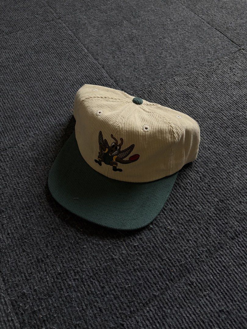 NEAT Corduroy Snapback Hat with Cricket Bug Embroidery (Category: Caps & Hats) located in Manila. Submitted by toys_hats005 (Listing ID 1470628756, Image 1). Description: - Brand: NEAT - Style: Corduroy cap with structured crown - Color: Cream body with dark green brim and strap - Design: Detailed cricket bug embroidery on front - Closure: Adjustable metal clasp (branded) - Condition: Pristine, clean fabric with no stains or wear marks.