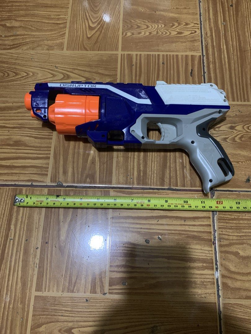 Nerf N-Strike Elite Disruptor Blaster (Category: Action & Battle Toys) located in Antipolo. Submitted by cebb888 (Listing ID 1470640017, Image 1). Description: - Model: Nerf N-Strike Elite Disruptor toy blaster - Colorway: Blue, white, and grey with an orange rotating drum - Capacity: Holds 6 darts (darts not included) - Performance: Fires up to 90 feet - Condition: Clean exterior with minor surface scuffs from previous playtime - Ideal for: Targ