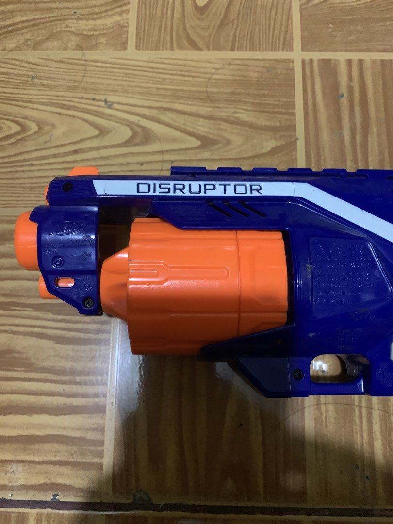 Nerf N-Strike Elite Disruptor Blaster (Category: Action & Battle Toys) located in Antipolo. Submitted by cebb888 (Listing ID 1470640017, Image 3). Description: - Model: Nerf N-Strike Elite Disruptor toy blaster - Colorway: Blue, white, and grey with an orange rotating drum - Capacity: Holds 6 darts (darts not included) - Performance: Fires up to 90 feet - Condition: Clean exterior with minor surface scuffs from previous playtime - Ideal for: Targ