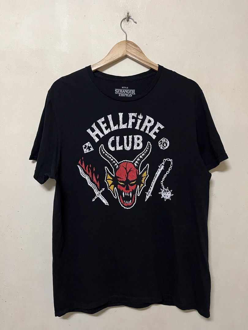 Netflix Stranger Things Hellfire Club T-Shirt (Category: Tshirts & Polo Shirts ) located in Manila. Submitted by jowellanam76428 (Listing ID 1470699643, Image 1). Description: - Official Netflix Stranger Things merchandise - Design: Hellfire Club graphic with red demon head, sword, and flail on the chest - Color: Classic black - Fit: Standard casual fit with crew neck - Condition: Brand new with neck label intact.