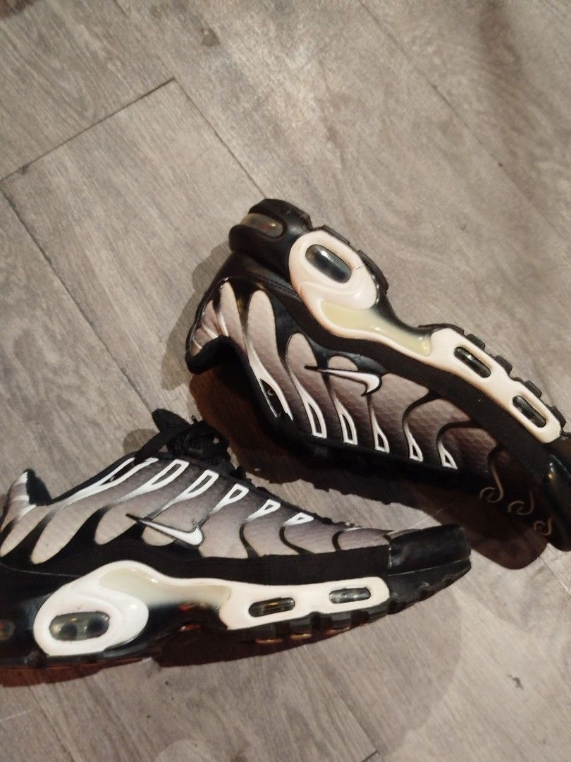 Nike Air Max Plus TN Black Grey Sneakers (Category: Sneakers) located in Quezon City. Submitted by epoquebyjaz (Listing ID 1470635623, Image 2). Description: - Model: Nike Air Max Plus TN - Colorway: Grey and black gradient with white midsole and black laces - Details: Iconic Tuned Air branding on heel and sole, intact upper mesh, and signature TPU wavy overlays - Condition: Visible wear on the rubber outsoles and tread; upper material is well-ma