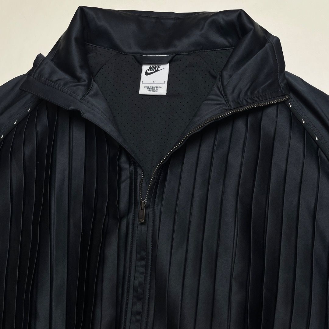 Nike Black Pleated Track Jacket (Category: Coats, Jackets and Outerwear) located in Caloocan City. Submitted by achilles_grails (Listing ID 1470727106, Image 3). Description: - Brand: Nike - Item: Full-Zip Track Jacket - Color: Black - Size: L (Tag intact) - Design: Unique pleated front and back panels - Material: Body: 96% polyester, 4% spandex | Lining: 79% polyester, 21% spandex - Features: Breathable mesh interior lining, mock neck collar, ri