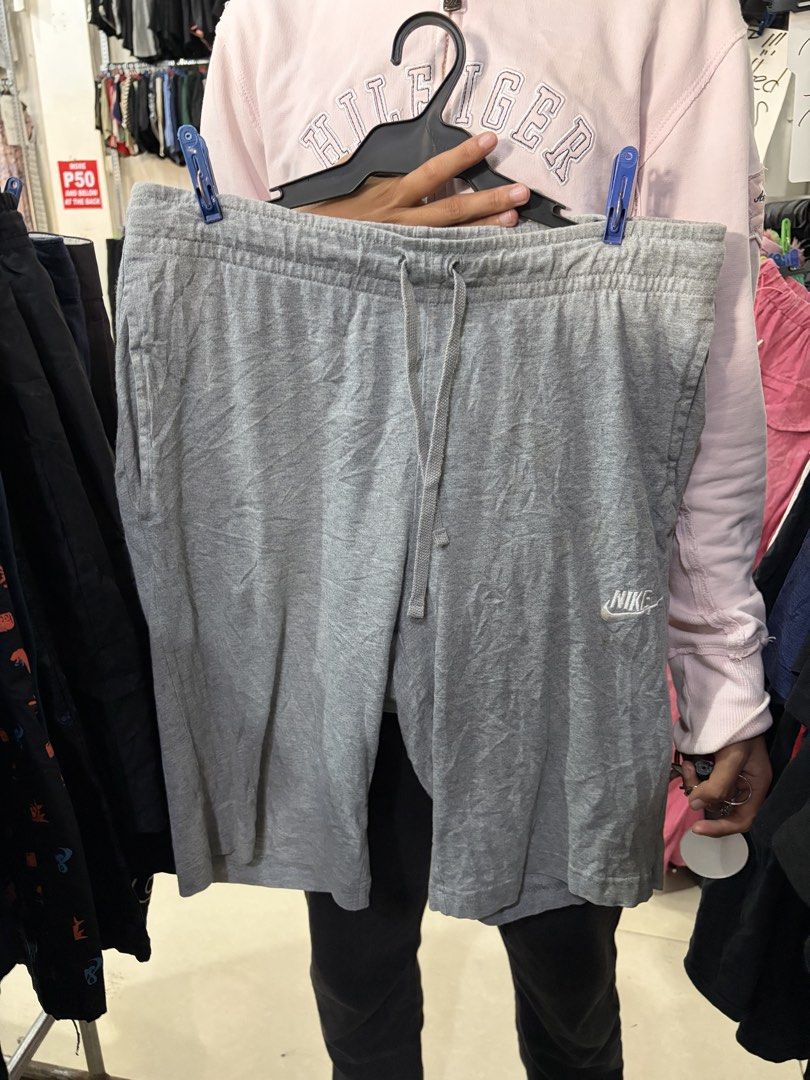 Nike Gray Drawstring Cotton Shorts Size M (Category: Shorts) located in Kalibo. Submitted by shi1234xs (Listing ID 1470621706, Image 1). Description: - Brand: Nike - Color: Gray - Size: Medium - Material: Soft, comfortable cotton (Made in China) - Fit: Standard fit with side pockets - Features: Elastic waistband with matching gray drawstring cords and white Nike swoosh logo on the lower left leg - Condition: Great for workouts, running errands, o
