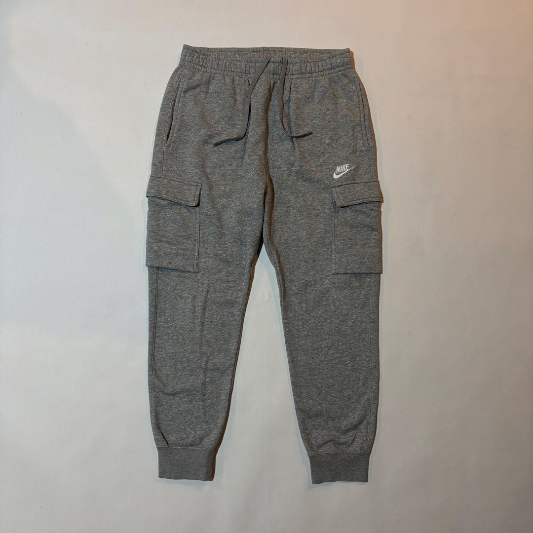 Nike Grey Cargo Sweatpants Joggers Size M (Category: Joggers) located in Dipolog. Submitted by dionato (Listing ID 1470666479, Image 2). Description: - Brand: Nike - Item: Cargo sweatpants - Color: Grey - Size: Men's Medium - Material: Super comfortable fleece - Features: Elastic waistband with adjustable drawstring, side pockets, utility cargo pockets on both legs, and cuffed ankles - Branding: Embroidered white Nike logo on the left leg - Condi