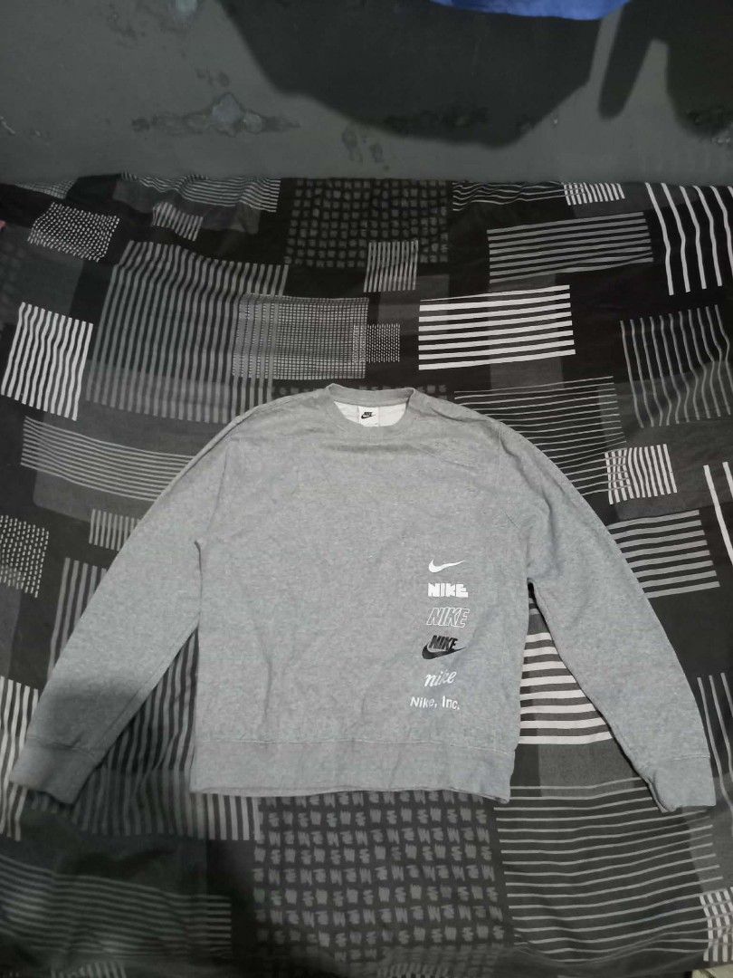 Nike Multi Logo Grey Sweatshirt Size S (Category: Coats, Jackets and Outerwear) located in Panabo. Submitted by khimmyirish_ki021126 (Listing ID 1470581592, Image 2). Description: - Brand: Nike - Style: Crewneck pullover sweatshirt - Color: Grey - Size: S (Measures approx. 23-24 inches across) - Material: 80% Cotton, 20% Polyester - Design: Multiple stacked logo prints on the bottom front - Origin: Made in Malaysia - Condition: Great for comforta