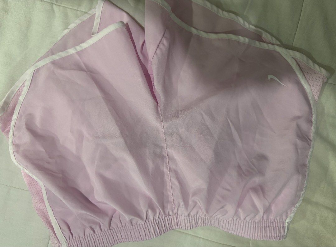 Nike Pink Running Shorts (Category: Shorts) located in Manila. Submitted by decluterthings888 (Listing ID 1470559949, Image 1). Description: - Brand: Nike - Color: Light pink with white trim - Size: xs- women L on tag for children size - Features: Elastic waistband, inner drawstring, and built-in liner - Material: Lightweight and breathable - Condition: Great for workouts, running, or casual lounging.