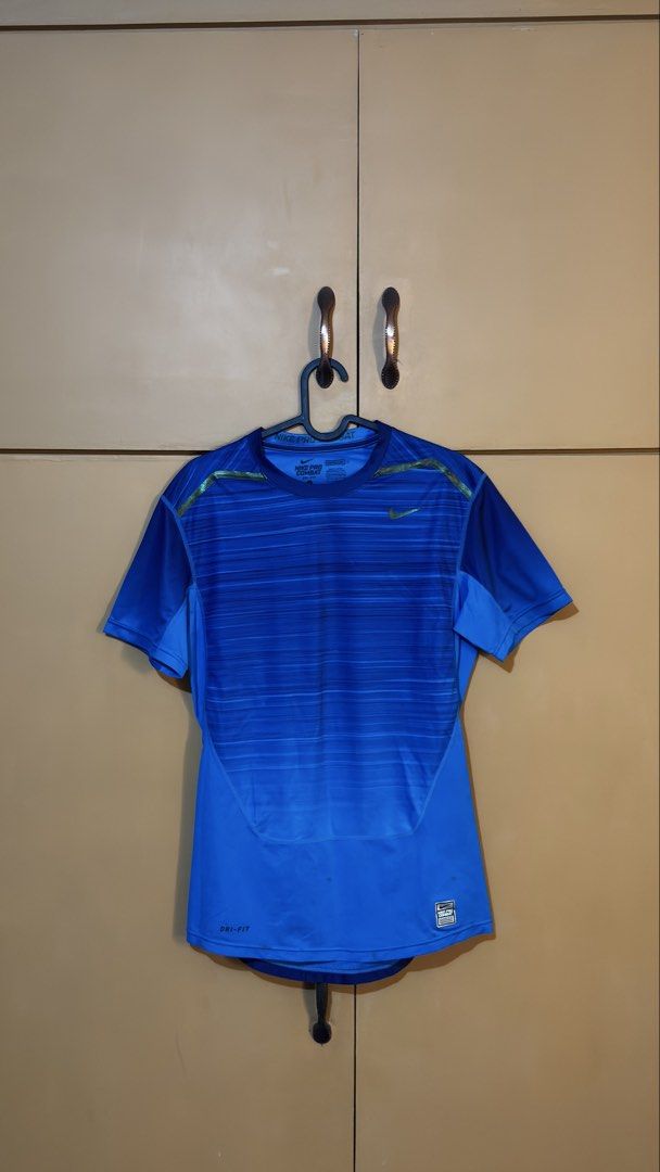 Nike Pro Combat Dri-Fit Blue Athletic Shirt (Category: Activewear) located in Manila. Submitted by reinrenren (Listing ID 1470621128, Image 1). Description: - Brand: Nike Pro Combat - Color/Design: Blue gradient horizontal stripes - Technology: Dri-Fit for moisture-wicking and comfort - Fit: Lightweight compression fit with round neckline - Details: Authentic patch near bottom hem, signature branding inside collar - Ideal for: Gym workouts, runni