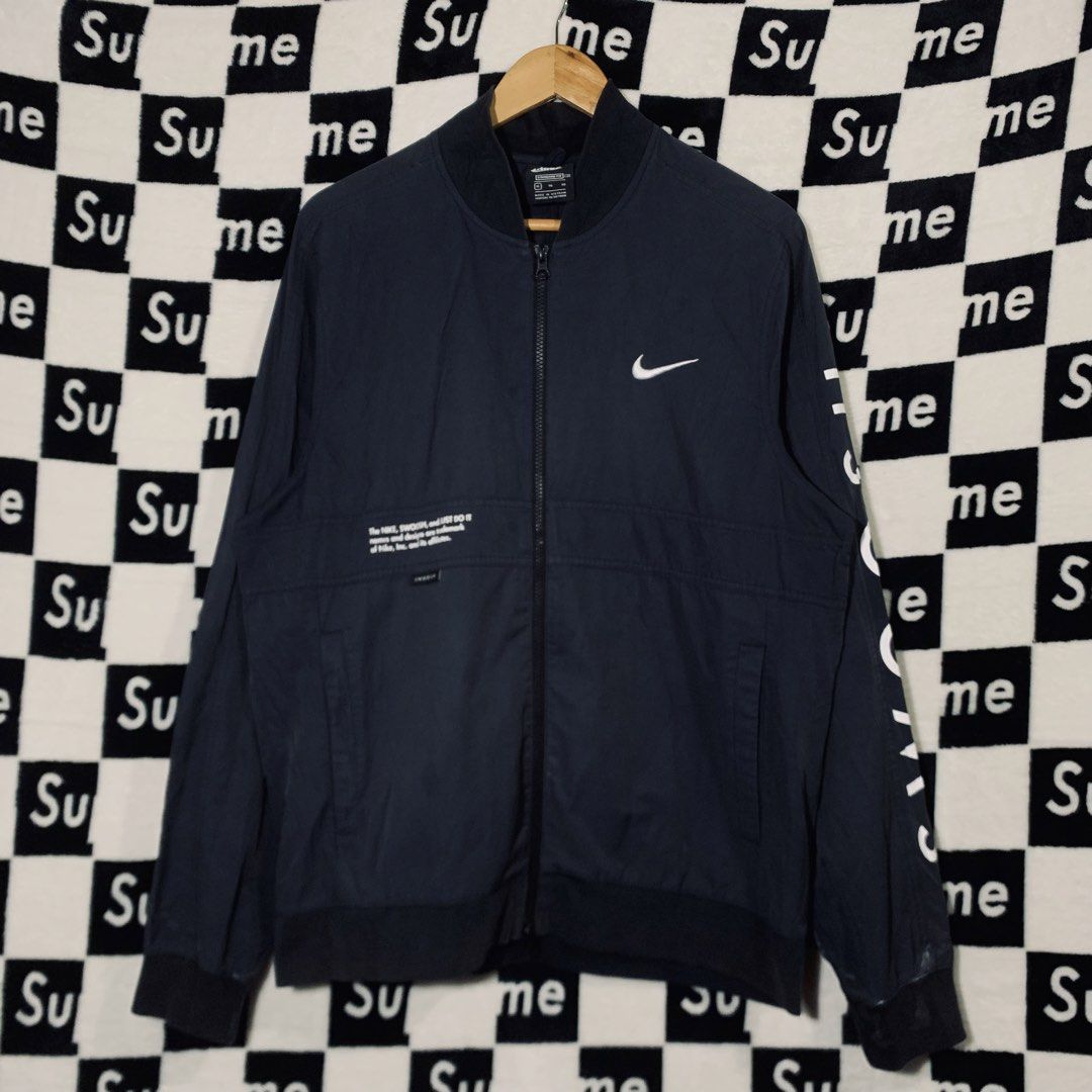 Nike Swoosh Bomber Jacket Navy Blue XL (Category: Coats, Jackets and Outerwear) located in Manila. Submitted by icemike444 (Listing ID 1470690959, Image 1). Description: - Brand: Nike - Style: Bomber jacket - Color: Dark navy blue - Size: XL (Standard fit) - Design: Full zip front, ribbed collar and cuffs - Details: Bold white Swoosh text down the left sleeve, trademark graphics on front right chest and large on upper back - Condition: Excellent 
