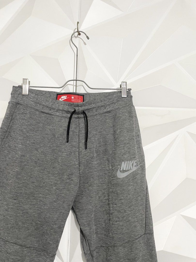 Nike Tech Fleece Grey Joggers Pants (Category: Joggers) located in Cabuyao City. Submitted by ParadisethriftedPh (Listing ID 1470648773, Image 3). Description: Cr: 9.8/10 Dimensions Waist: 30-34 Length: 35 - Authentic Nike Tech Fleece sweatpants in grey - Elastic waistband with dark grey adjustable drawstring - Signature black taped zipper pocket on the right leg - Reflective Nike logo near the left hip for visibility - Comfortable ribbed ankle c