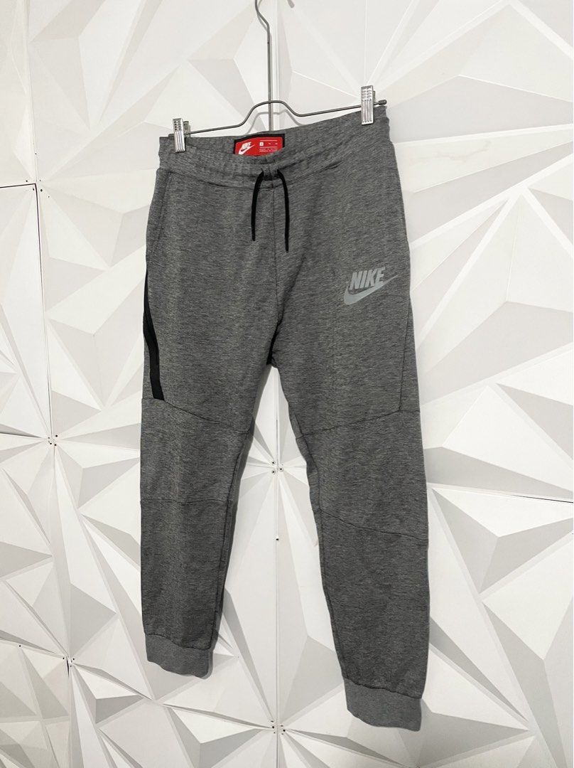 Nike Tech Fleece Grey Joggers Pants (Category: Joggers) located in Cabuyao City. Submitted by ParadisethriftedPh (Listing ID 1470648773, Image 2). Description: Cr: 9.8/10 Dimensions Waist: 30-34 Length: 35 - Authentic Nike Tech Fleece sweatpants in grey - Elastic waistband with dark grey adjustable drawstring - Signature black taped zipper pocket on the right leg - Reflective Nike logo near the left hip for visibility - Comfortable ribbed ankle c