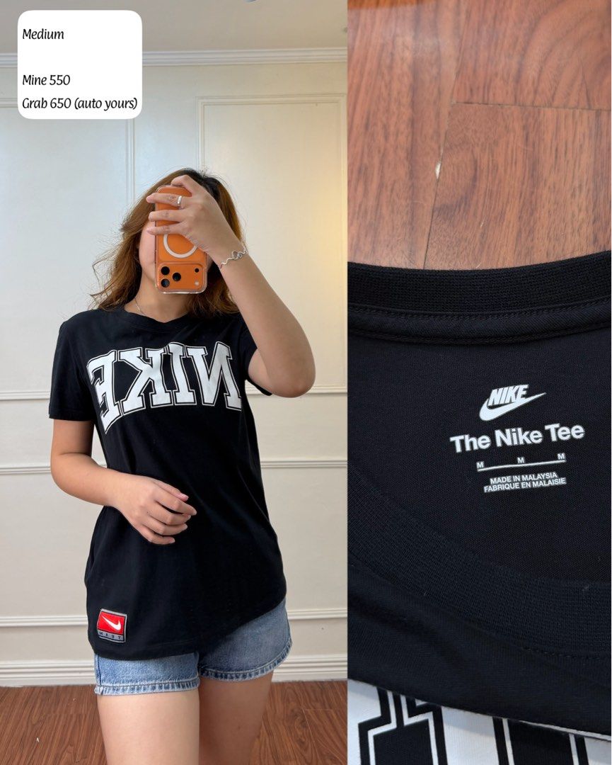 Nike The Nike Tee Black T-Shirt Medium (Category: Tshirts & Polo Shirts ) located in Manila. Submitted by angelll0123 (Listing ID 1470706351, Image 1). Description: - Brand: Nike - Color: Black with big white graphic lettering on chest - Size: Medium (Regular fit, standard crew neck) - Detail: Small red Nike patch near the bottom hem - Origin: Made in Malaysia - Condition/Style: Easy everyday piece, great to pair with jeans or shorts.