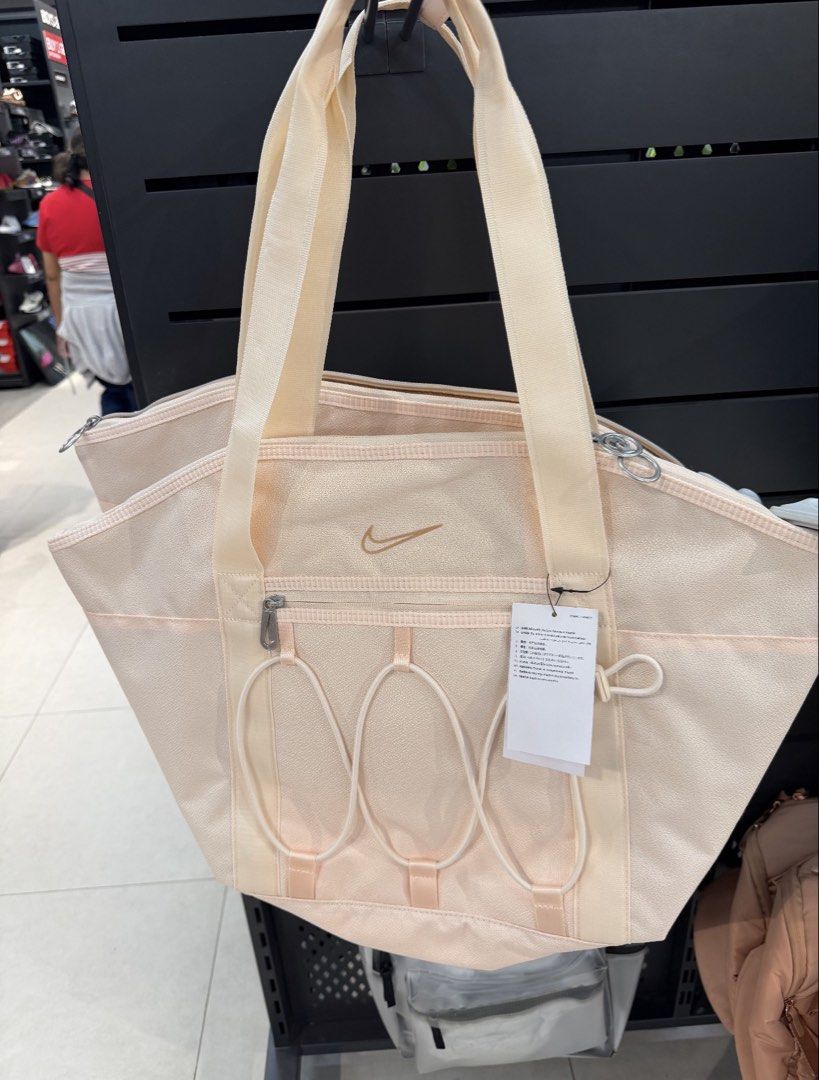 Nike Training One Tote Gym Bag Pink (Category: Tote Bags) located in Cagayan de Oro. Submitted by grabmystufff (Listing ID 1470568686, Image 3). Description: - Brand: Nike One Tote Bag - Color: Soft Pink - Condition: Brand new with original store tag attached, clean and unused - Features: Roomy interior with organizational compartments, front zip pocket, and exterior bungee cord details - Handles: Dual top carry handles - Perfect for: Daily use, 